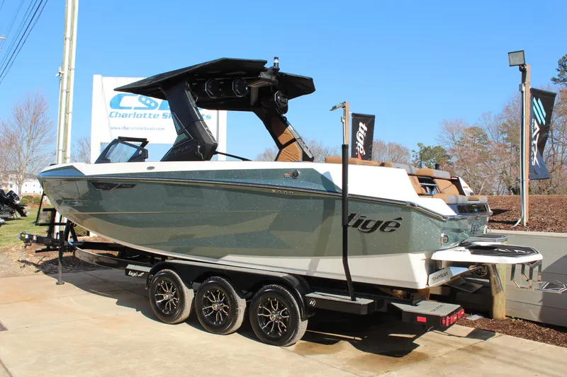 Slide: The Image of 2026 Tigé Ultré 25ZX boat on trailer, displayed outdoors at Charlotte Ski Boats. - 4