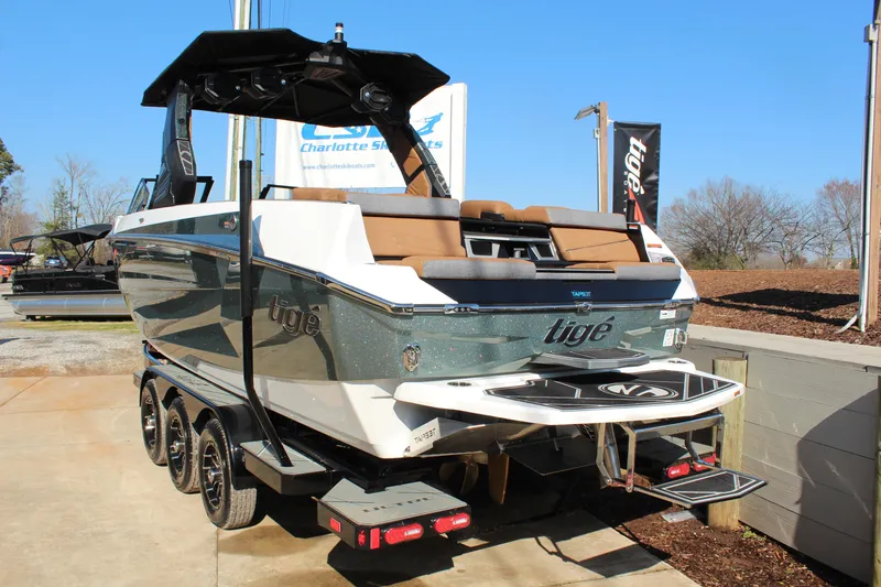 Slide: The Image of 2026 Tigé Ultré 25ZX boat on trailer, displayed outdoors under clear blue sky. - 5