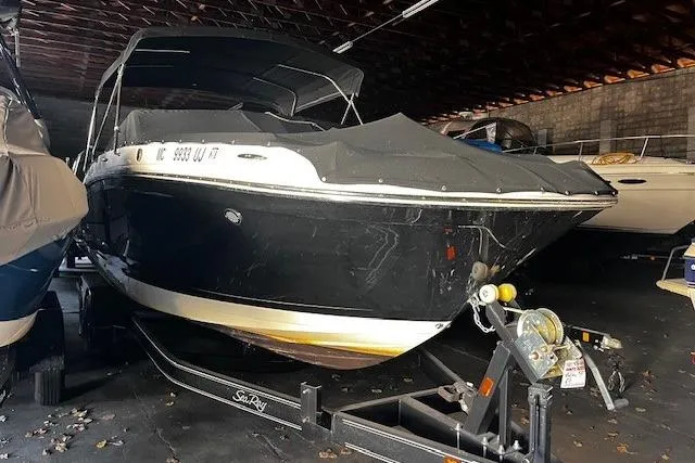 Slide: The Image of 2018 Sea Ray SDX 270 boat in storage, black exterior, on trailer. - 13
