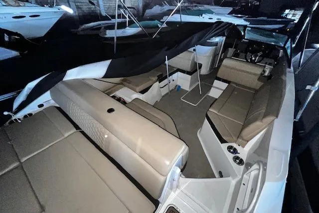 Slide: The Image of 2018 Sea Ray SDX 270 boat interior with beige seating and covered deck. - 16