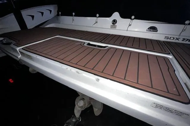 Slide: The Image of 2018 Sea Ray SDX 270 boat deck with wood-like finish and storage compartment. - 22