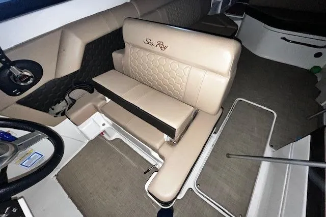 Slide: The Image of 2018 Sea Ray SDX 270 boat interior with beige seating and steering wheel. - 35