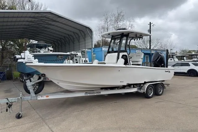 The Image of 2026 Tidewater 2500 Carolina Bay boat on trailer, parked outdoors under cloudy sky. - 1