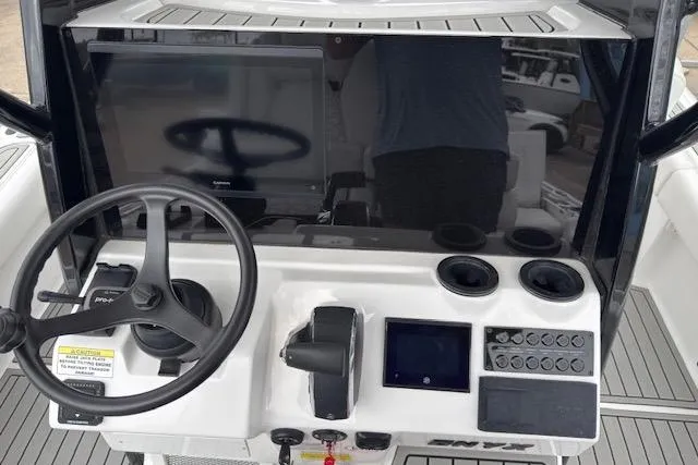 Slide: The Image of 2026 Tidewater 2500 Carolina Bay boat dashboard with steering wheel and electronic controls. - 12