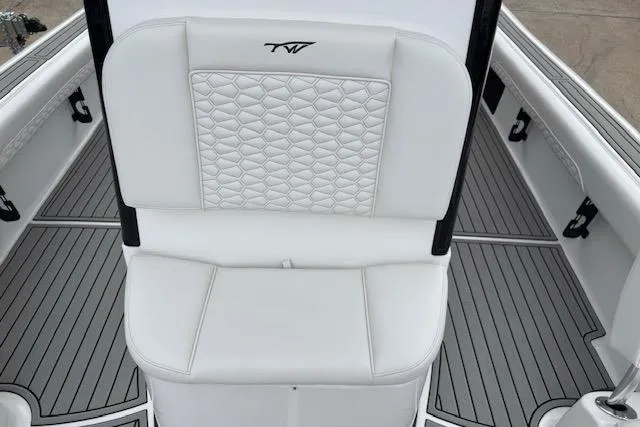 Slide: The Image of 2026 Tidewater 2500 Carolina Bay boat interior with white cushioned seating and sleek design. - 16