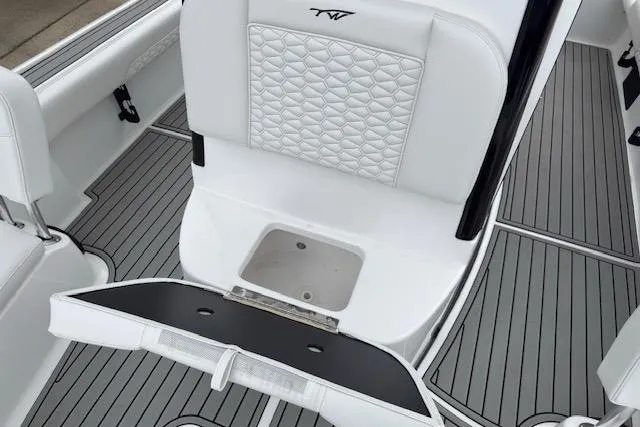 Slide: The Image of 2026 Tidewater 2500 Carolina Bay boat interior with white seating and storage compartment. - 18