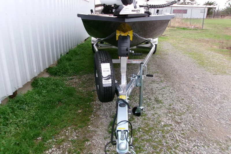 Slide: The Image of 2026 Xpress H22B Bay boat on trailer, parked on gravel near metal building. - 17