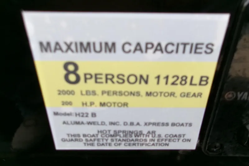 Slide: The Image of 2026 Xpress H22B Bay boat capacity label: 8 persons, 1128 lbs, 200 HP motor. - 2