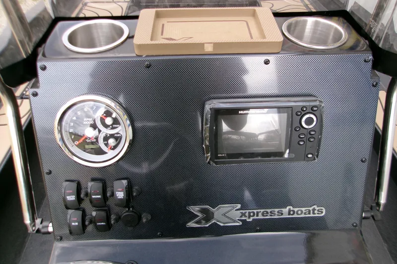 Slide: The Image of 2026 Xpress H22B Bay boat dashboard with gauges, switches, and navigation display. - 4