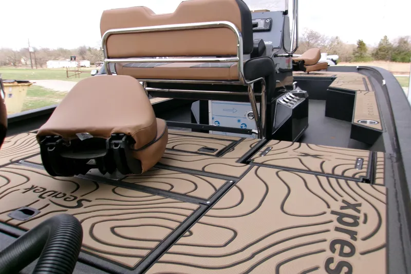 Slide: The Image of 2026 Xpress H22B Bay boat interior with tan seating and patterned flooring. - 6