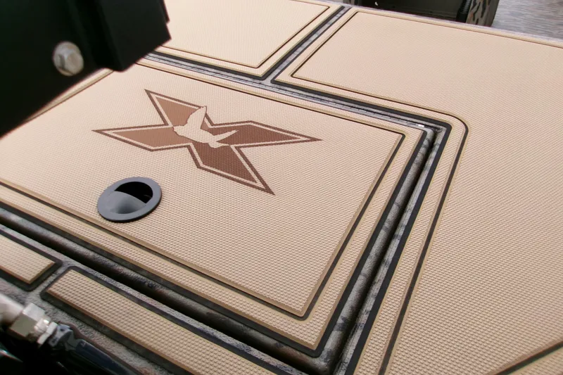 Slide: The Image of 2026 Xpress Bayou 180CC boat deck with logo and textured surface. - 11