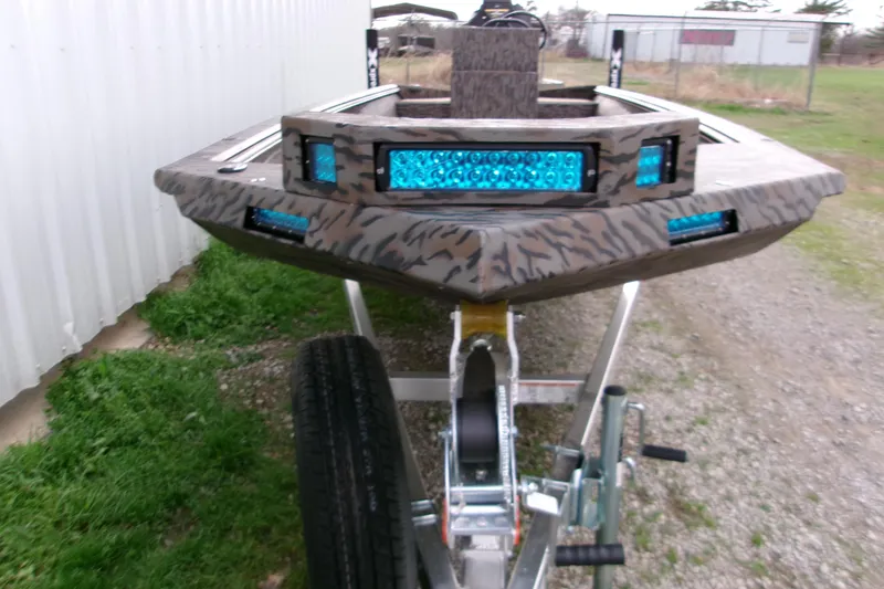 Slide: The Image of 2026 Xpress Bayou 180CC boat with blue LED lights on trailer. - 14