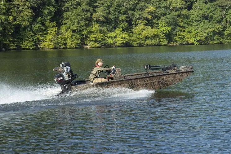 Slide: The Image of Manufacturer Provided Image: 2026 Xpress Bayou 180CC boat speeding on a lake with lush green forest backdrop. - 4