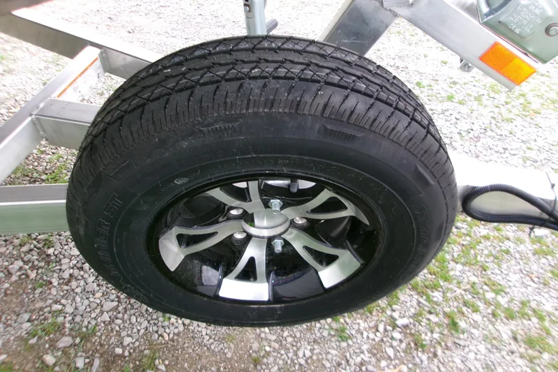 Slide: The Image of 2026 Xpress Bayou 180CC trailer wheel on gravel surface. - 6