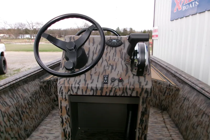 Slide: The Image of 2026 Xpress Bayou 180CC boat interior with camouflage design and steering console. - 8