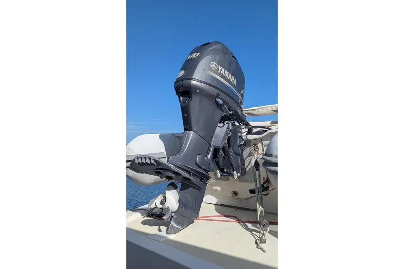 Slide: The Image of Outboard motor on 2005 Kadey-Krogen Pilothouse boat, clear blue sky background. - 10