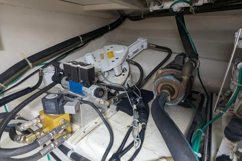 Slide: The Image of Engine room of a 2005 Kadey-Krogen Pilothouse, showcasing mechanical components and wiring. - 100