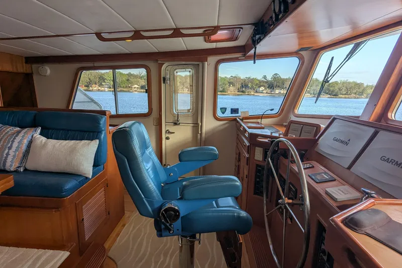 Slide: The Image of 2005 Kadey-Krogen Pilothouse interior with blue seating, steering wheel, and navigation equipment. - 104