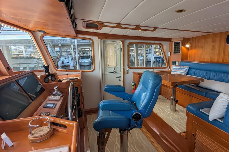 Slide: The Image of 2005 Kadey-Krogen Pilothouse interior with blue seating, wooden accents, and navigation equipment. - 106