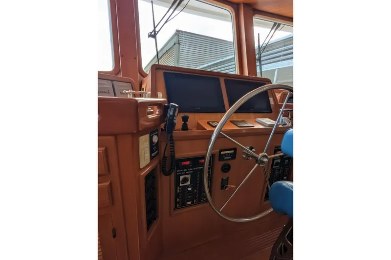 Slide: The Image of 2005 Kadey-Krogen Pilothouse interior with steering wheel and navigation equipment. - 107