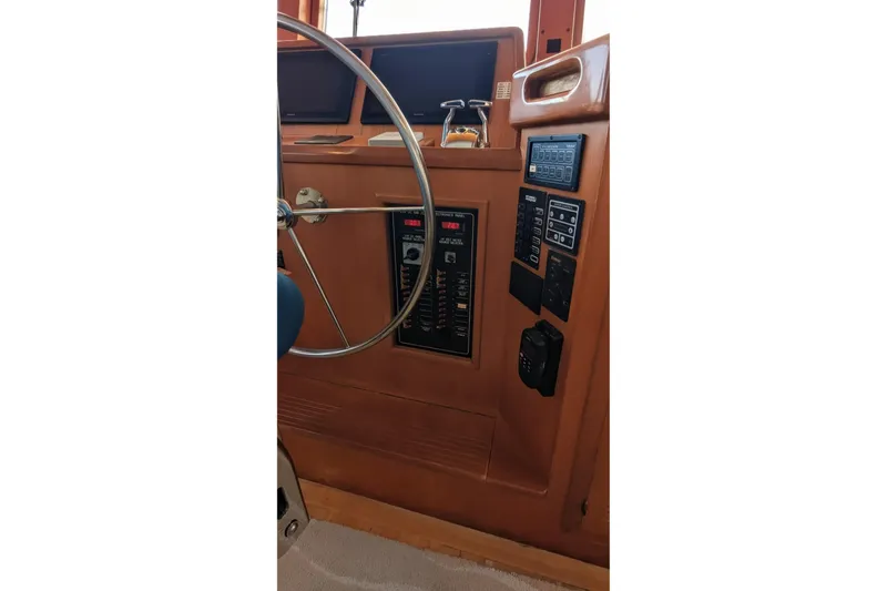 Slide: The Image of 2005 Kadey-Krogen Pilothouse helm with steering wheel and control panels. - 108