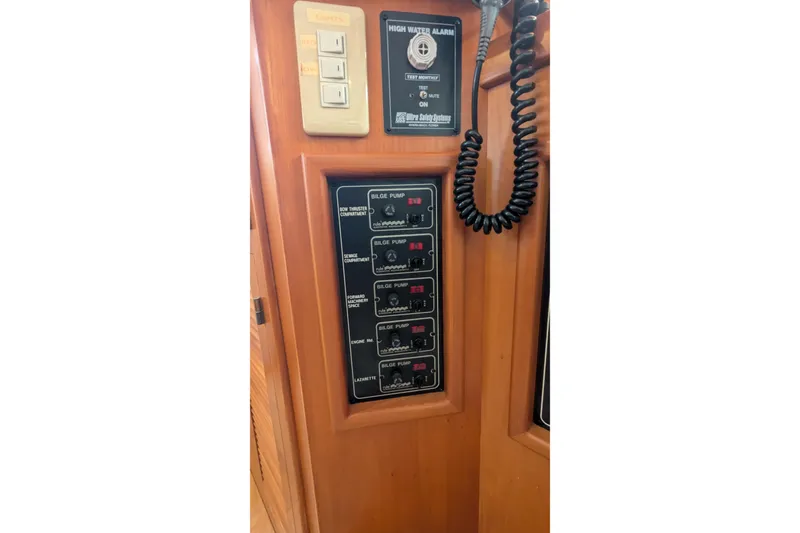 Slide: The Image of 2005 Kadey-Krogen Pilothouse control panel with high water alarm and bilge pump switches. - 112
