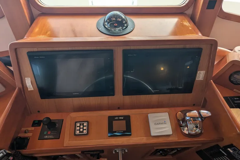 Slide: The Image of 2005 Kadey-Krogen Pilothouse dashboard with Garmin screens and navigation controls. - 113