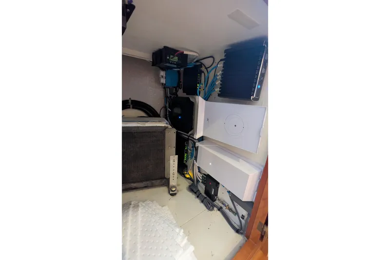 Slide: The Image of Electrical components inside a 2005 Kadey-Krogen Pilothouse boat, showcasing wiring and equipment. - 122