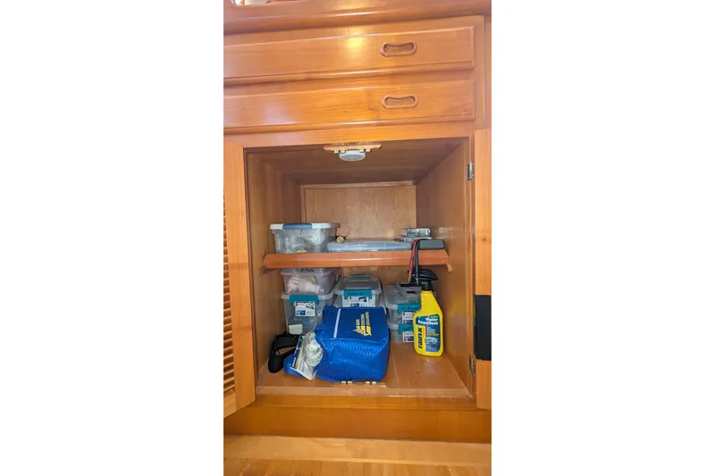 Slide: The Image of 2005 Kadey-Krogen Pilothouse cabinet with organized storage and cleaning supplies. - 125