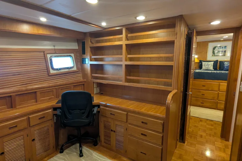 Slide: The Image of Luxurious 2005 Kadey-Krogen Pilothouse interior with wooden desk, shelving, and cozy bedroom. - 127
