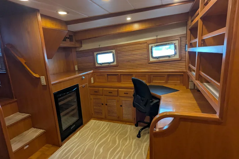 Slide: The Image of Luxurious 2005 Kadey-Krogen Pilothouse interior with wooden desk, chair, and shelving. - 128
