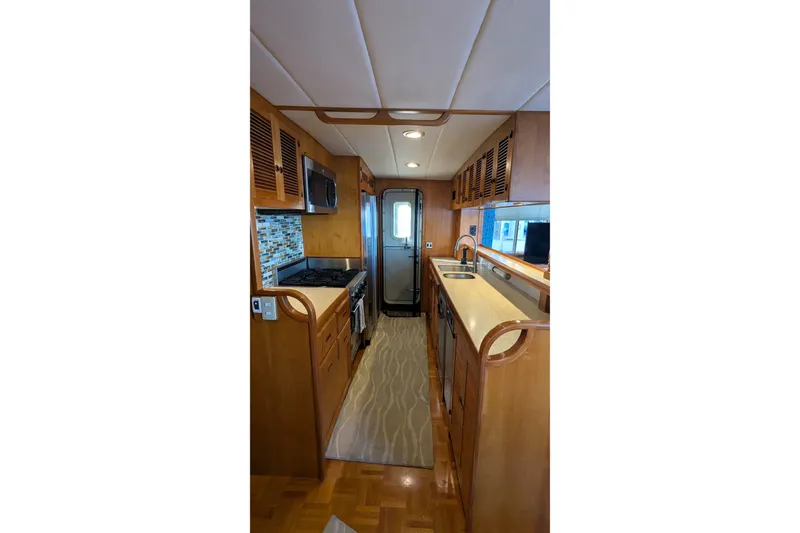 Slide: The Image of 2005 Kadey-Krogen Pilothouse kitchen with wood cabinetry, modern appliances, and sleek countertops. - 136