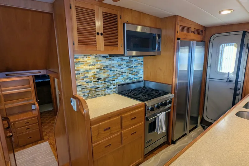 Slide: The Image of 2005 Kadey-Krogen Pilothouse kitchen with stainless appliances and wood cabinetry. - 137