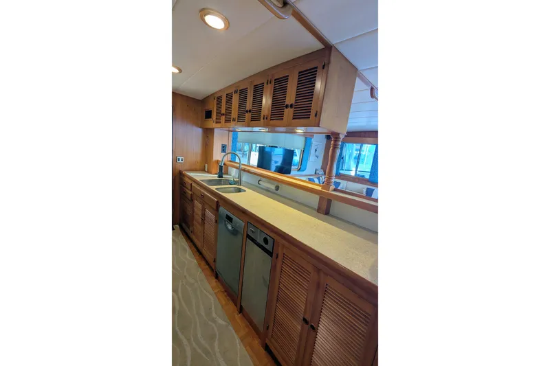 Slide: The Image of 2005 Kadey-Krogen Pilothouse kitchen with wooden cabinets and modern appliances. - 138