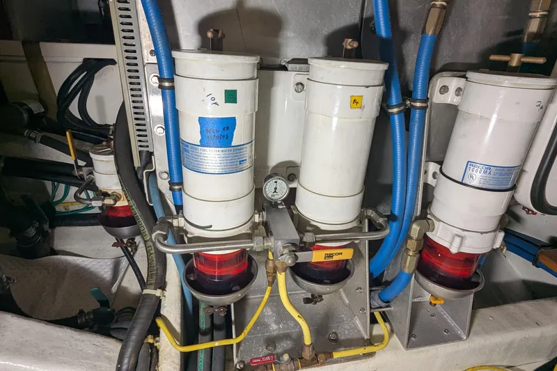 Slide: The Image of Engine room of 2005 Kadey-Krogen Pilothouse with fuel filter system and blue hoses. - 145