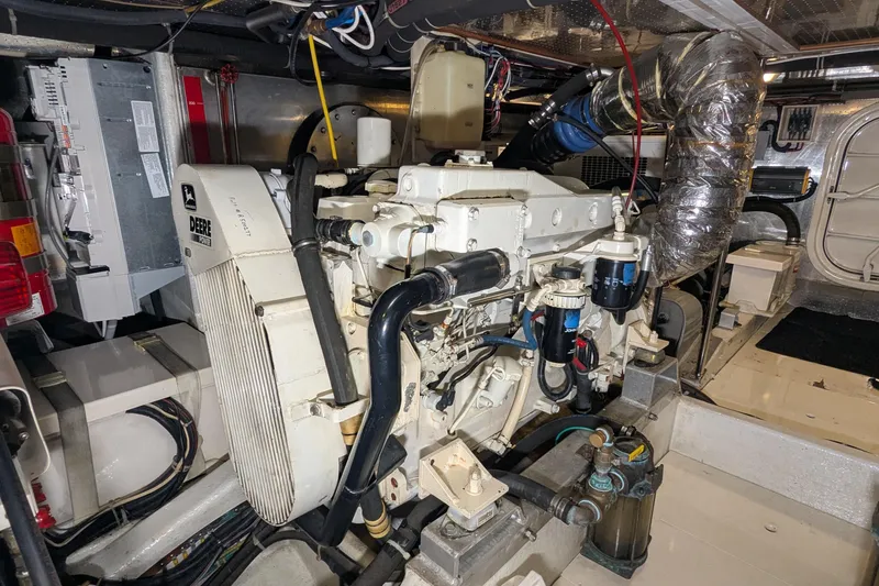 Slide: The Image of Engine room of a 2005 Kadey-Krogen Pilothouse, featuring a John Deere marine engine. - 149