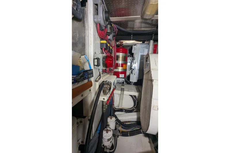 Slide: The Image of Engine room of 2005 Kadey-Krogen Pilothouse with wiring, fire extinguisher, and equipment. - 150