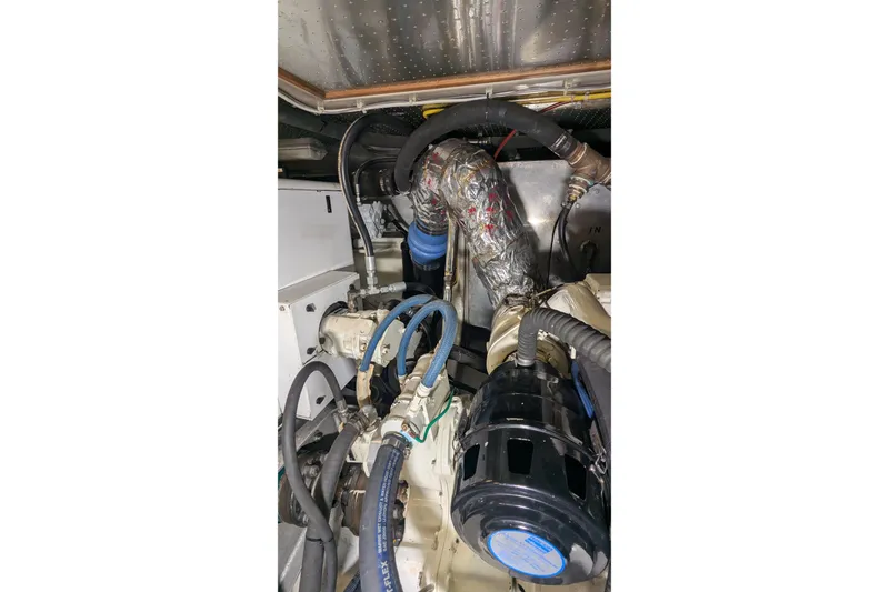 Slide: The Image of Engine room of 2005 Kadey-Krogen Pilothouse with visible hoses and components. - 152