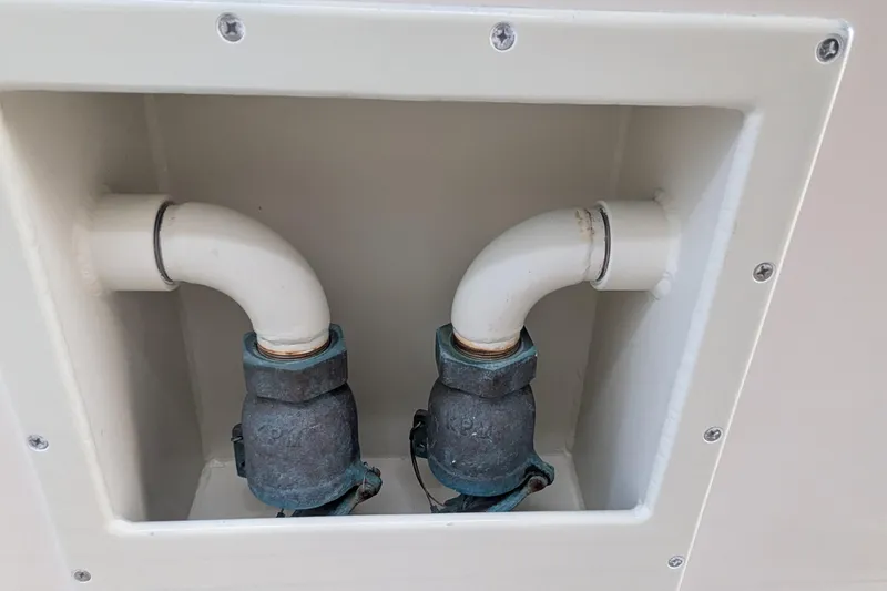 Slide: The Image of Plumbing components on a 2005 Kadey-Krogen Pilothouse boat, featuring two white pipes and valves. - 16