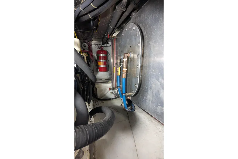 Slide: The Image of Engine room of 2005 Kadey-Krogen Pilothouse with hoses and fire extinguisher. - 163