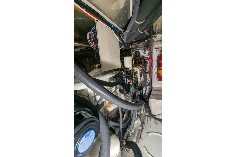 Slide: The Image of Engine room of a 2005 Kadey-Krogen Pilothouse with visible hoses and wiring. - 164