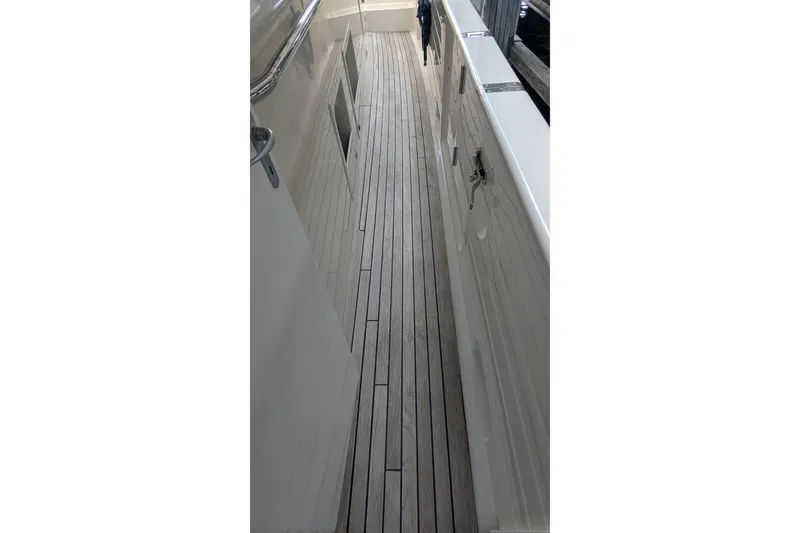 Slide: The Image of 2005 Kadey-Krogen Pilothouse yacht deck with wooden flooring and metal railings. - 17