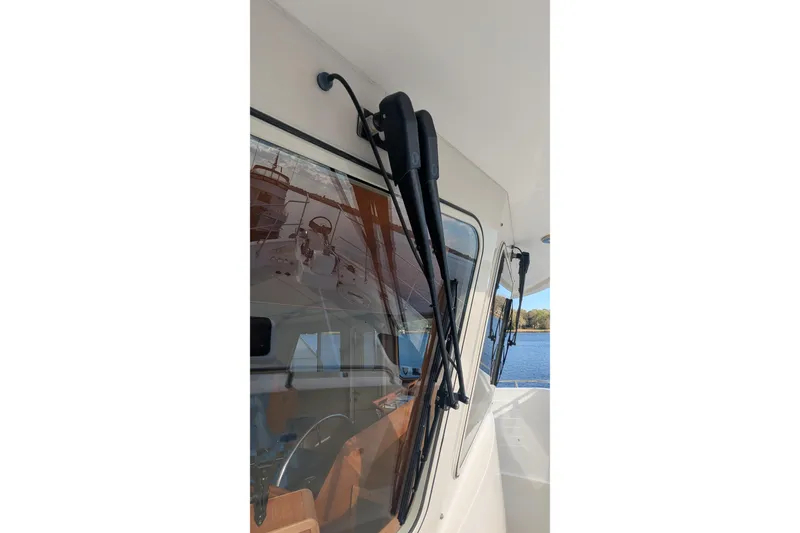 Slide: The Image of 2005 Kadey-Krogen Pilothouse boat window with wipers, reflecting marina view. - 25