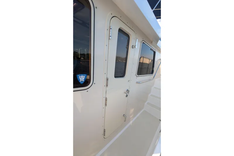 Slide: The Image of 2005 Kadey-Krogen Pilothouse exterior with door and windows, showcasing nautical design. - 38