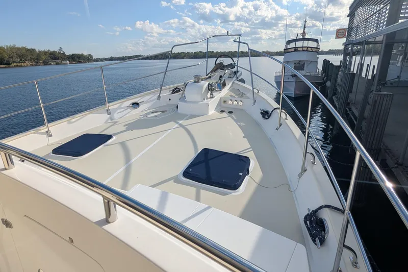 Slide: The Image of 2005 Kadey-Krogen Pilothouse yacht docked, showcasing spacious deck and serene waterfront view. - 4