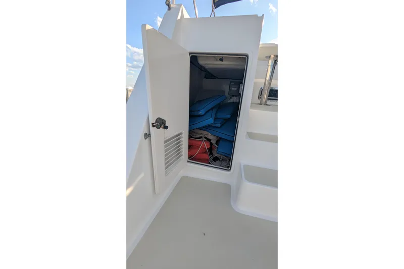Slide: The Image of 2005 Kadey-Krogen Pilothouse storage compartment with blue cushions and equipment. - 43
