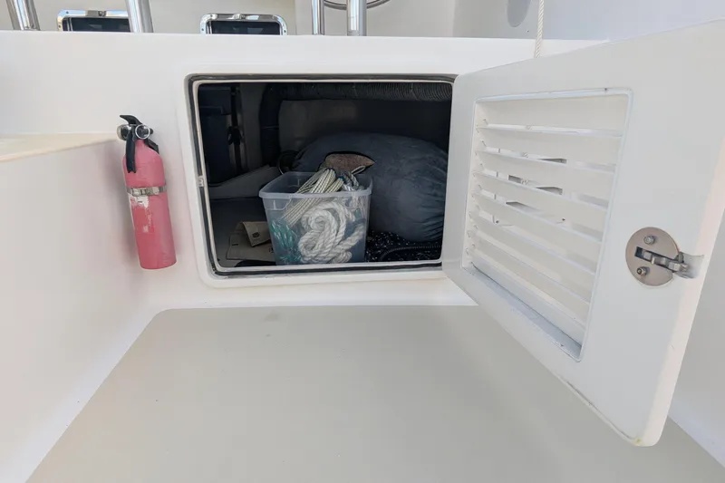 Slide: The Image of Storage compartment on 2005 Kadey-Krogen Pilothouse with fire extinguisher and rope container. - 44