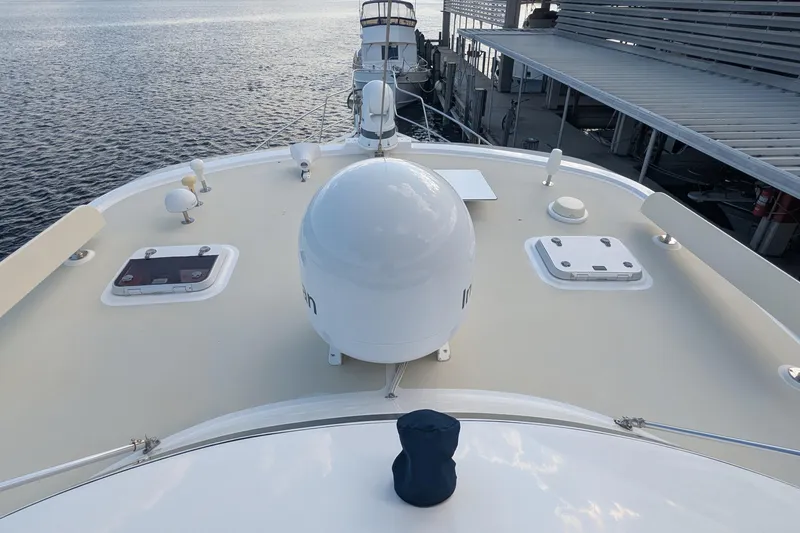 Slide: The Image of 2005 Kadey-Krogen Pilothouse yacht deck with radar dome and hatches, docked by the water. - 46