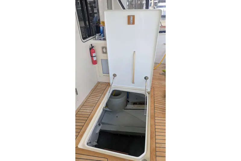 Slide: The Image of Open hatch on 2005 Kadey-Krogen Pilothouse boat deck, revealing storage area. - 64