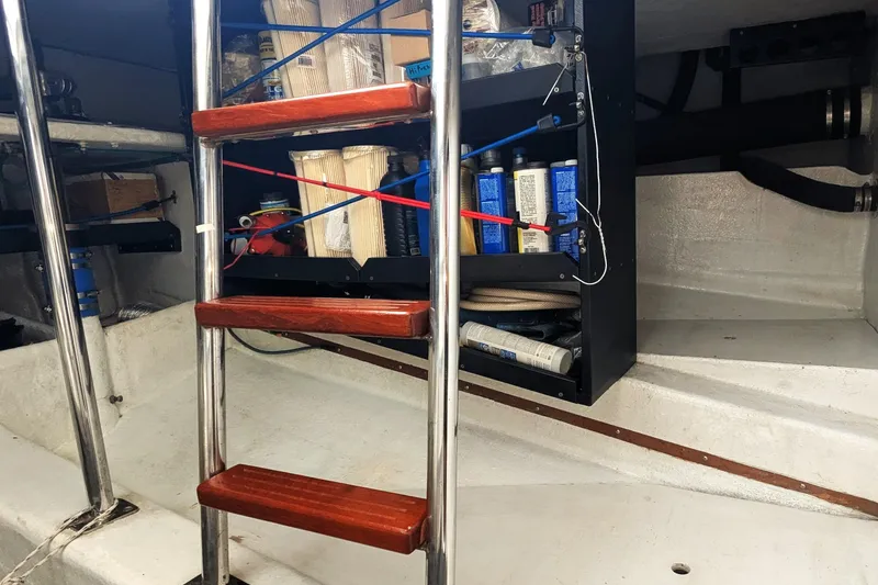 Slide: The Image of Engine room of 2005 Kadey-Krogen Pilothouse with ladder and storage shelves. - 65